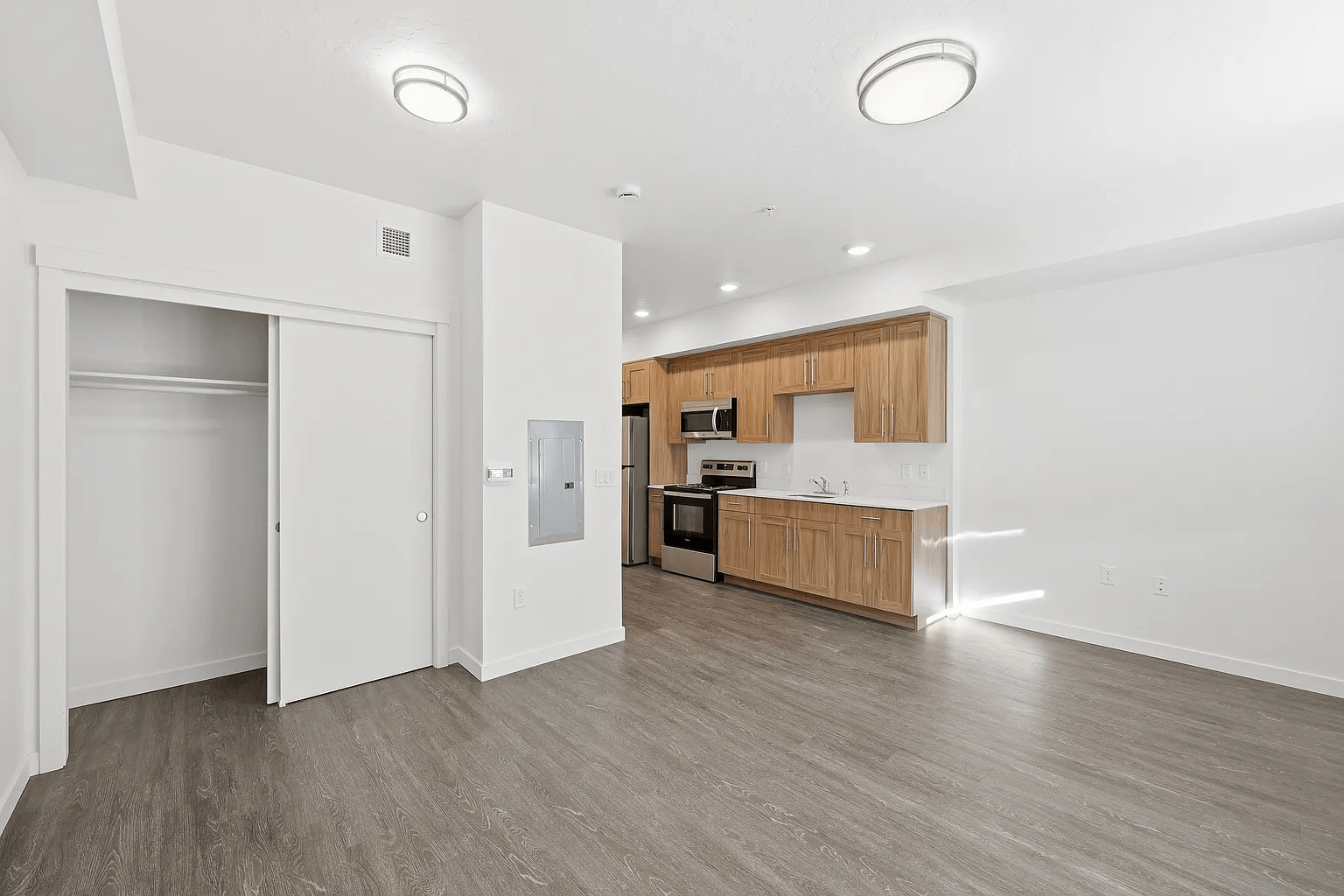 A kitchen area with a microwave, oven, and refrigerator.